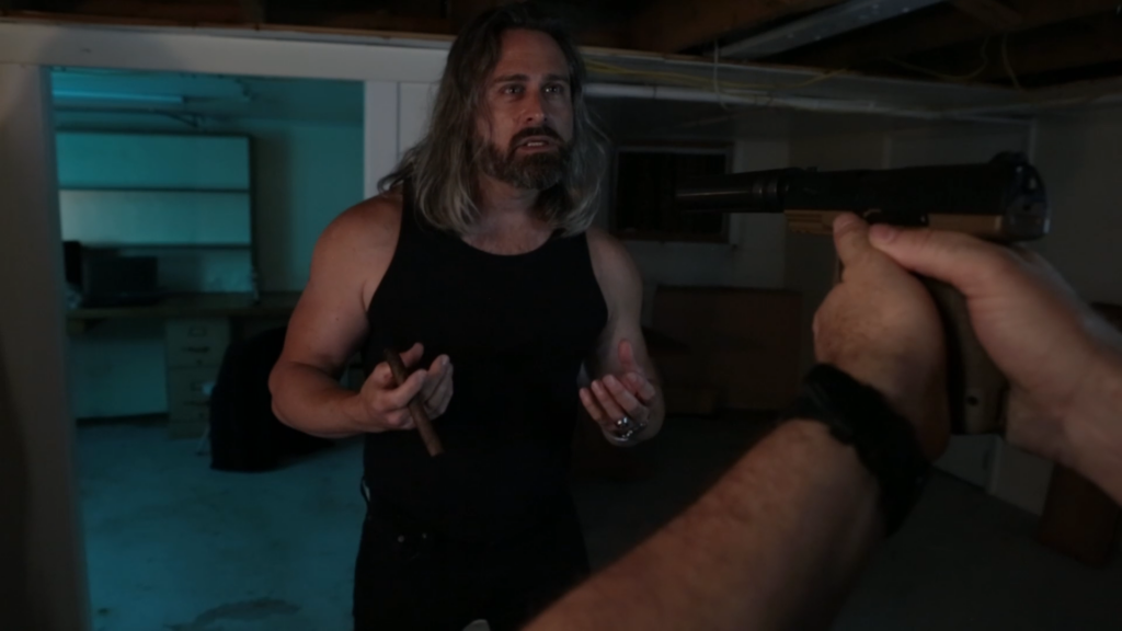 Snapshot of Word and Deed teaser Victor with gun pointed at him